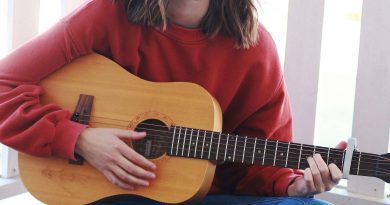 Justina Ward sitting with a guitar.