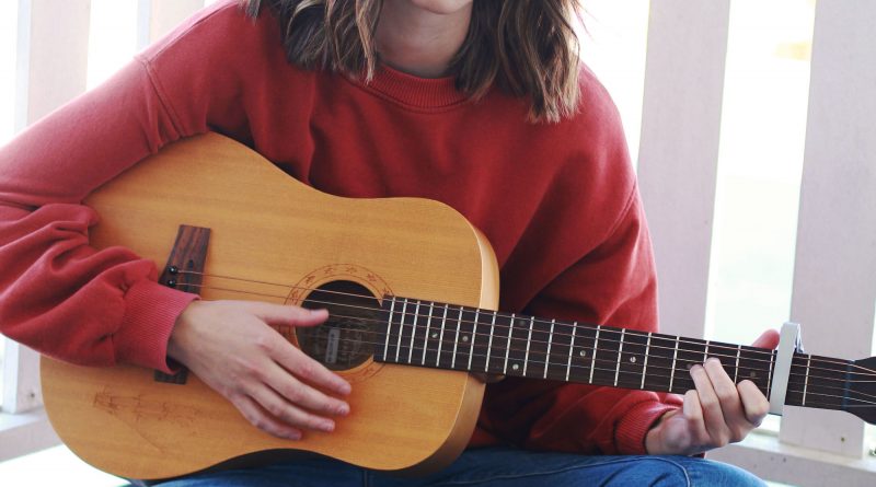 Justina Ward sitting with a guitar.